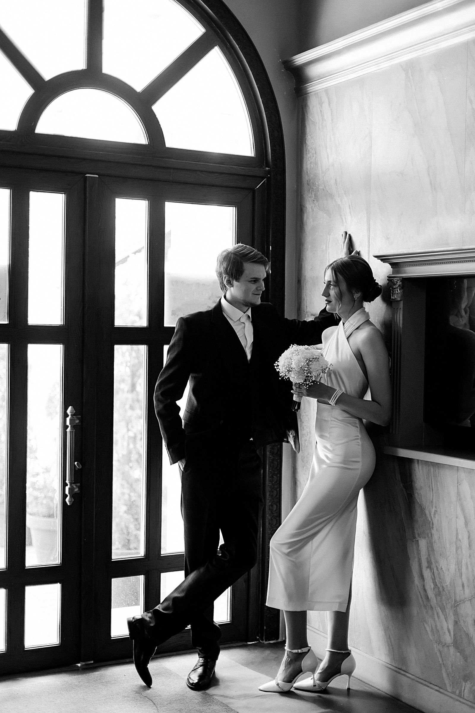A bride and groom standing together in a doorway