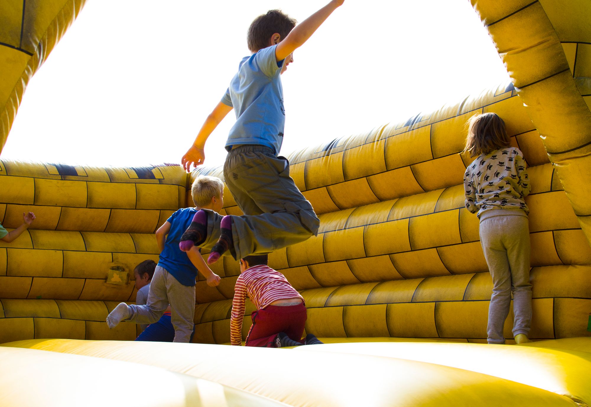 Kids jumping inside a bright yellow bounce house
