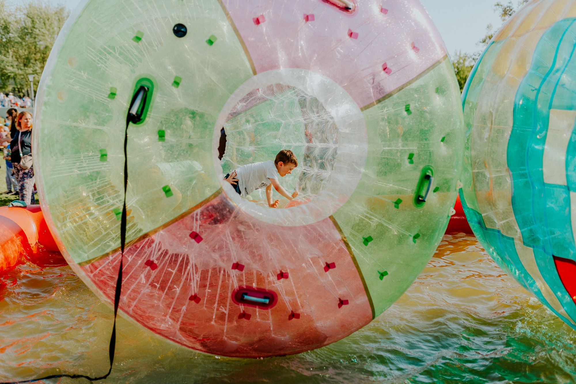 A child rolling inside a clear inflatable zorb ball