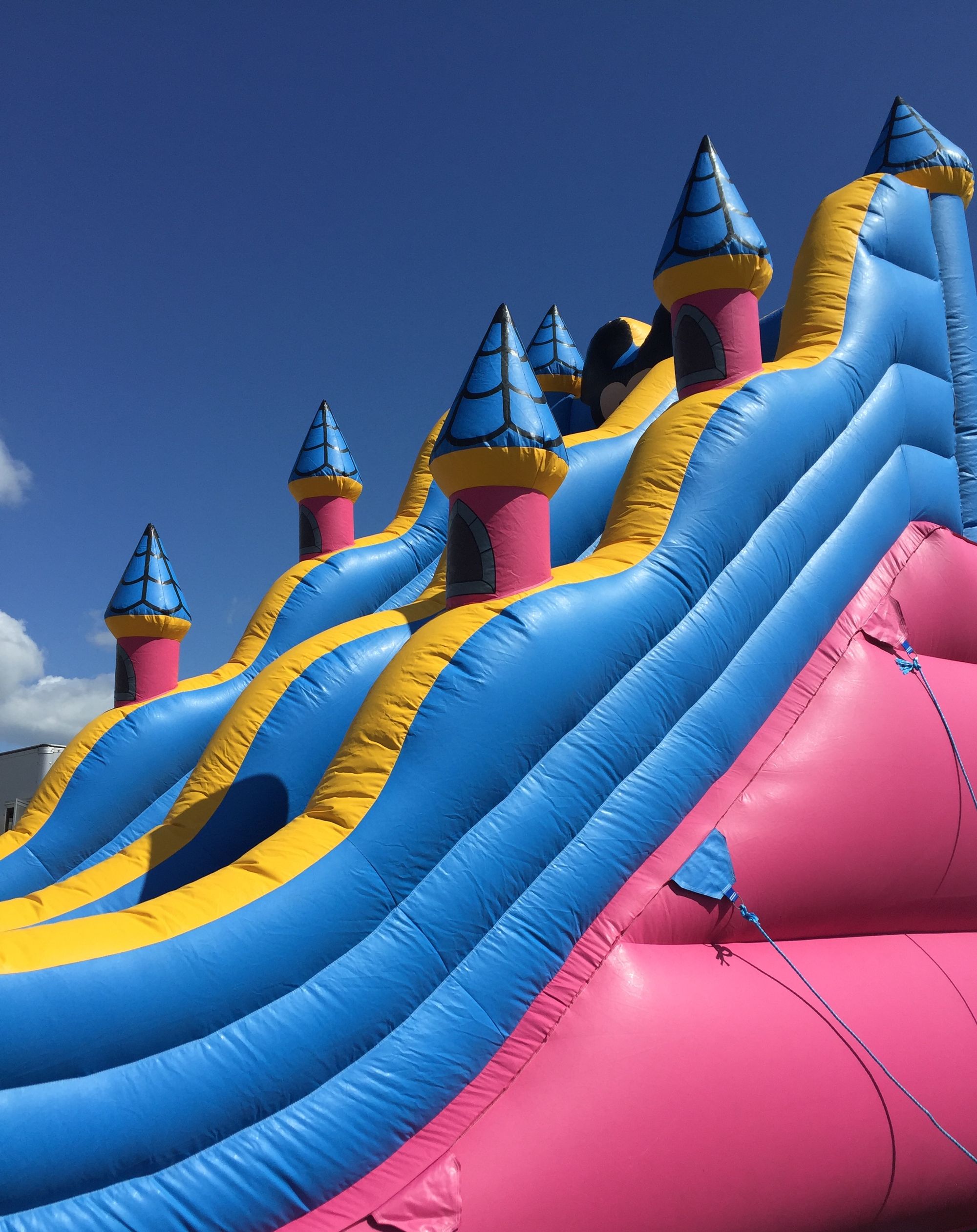 A towering blue and pink inflatable slide against the sky