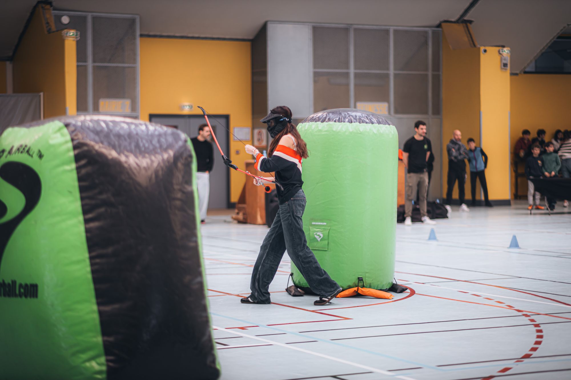 Players behind inflatable bunkers in an archery tag game