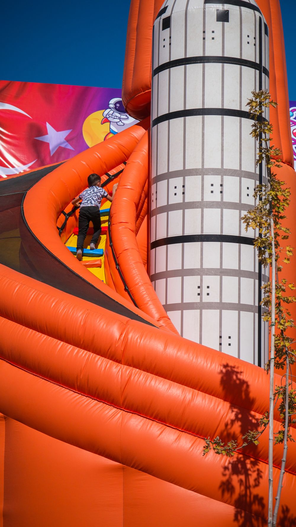 An orange inflatable combo with a climbing wall and slide