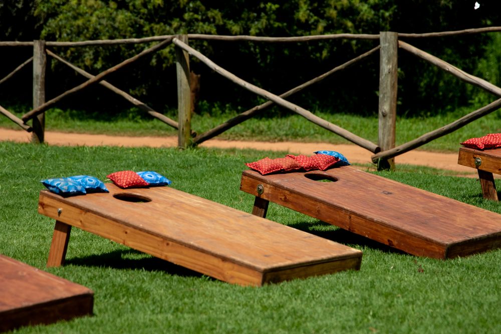 Two cornhole boards set up on a green lawn