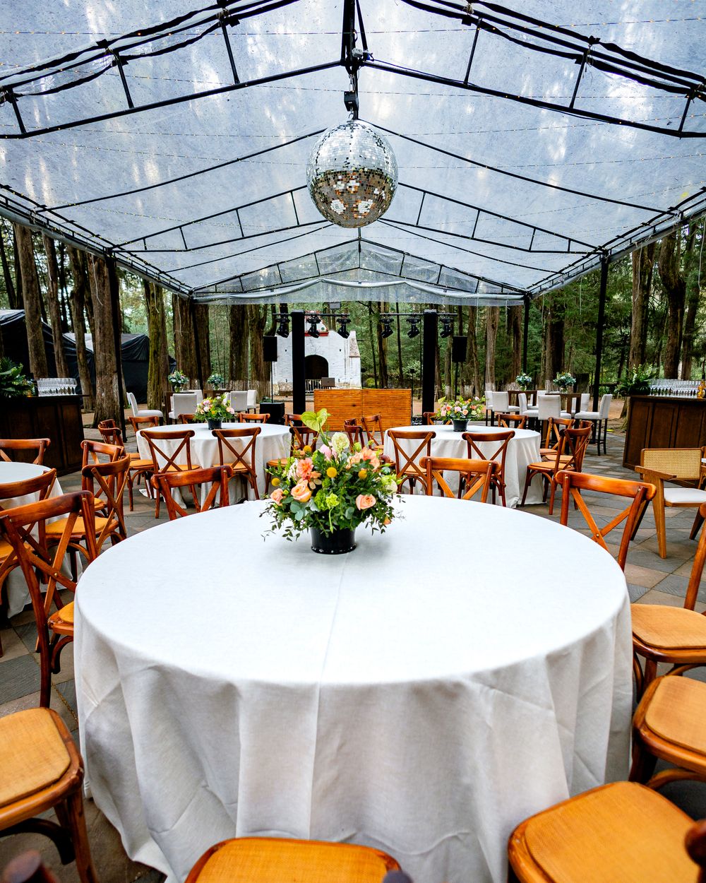 A white party tent with tables and floral centerpieces