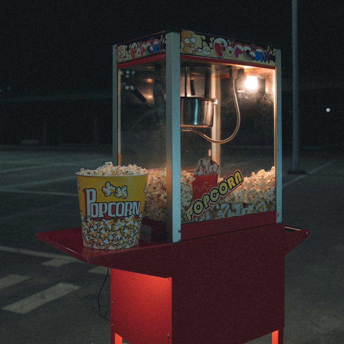 A glowing popcorn machine on a red cart