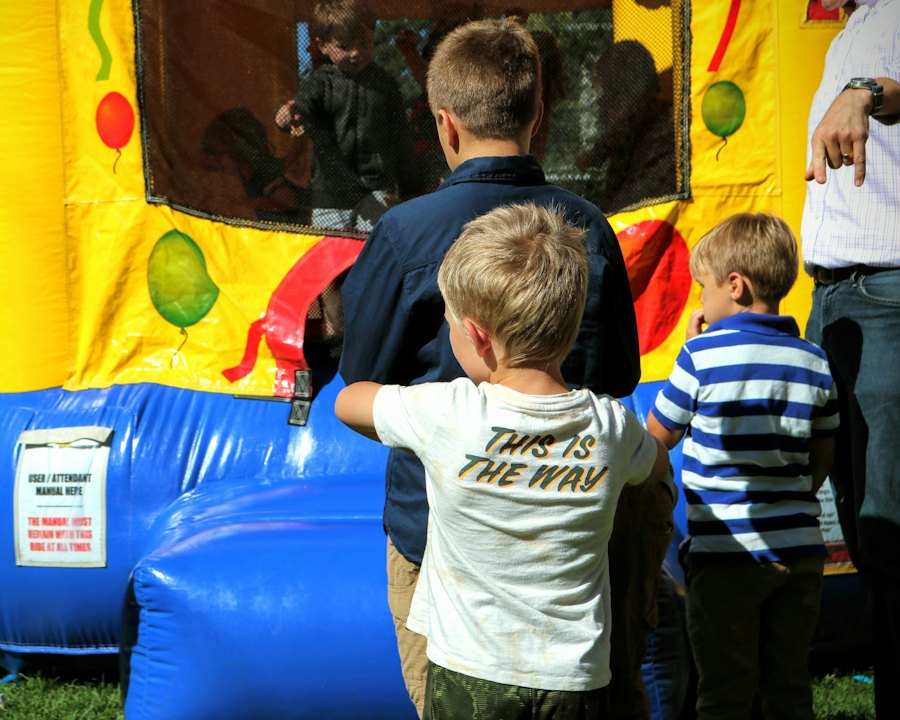 Children lined up at an inflatable with an attendant