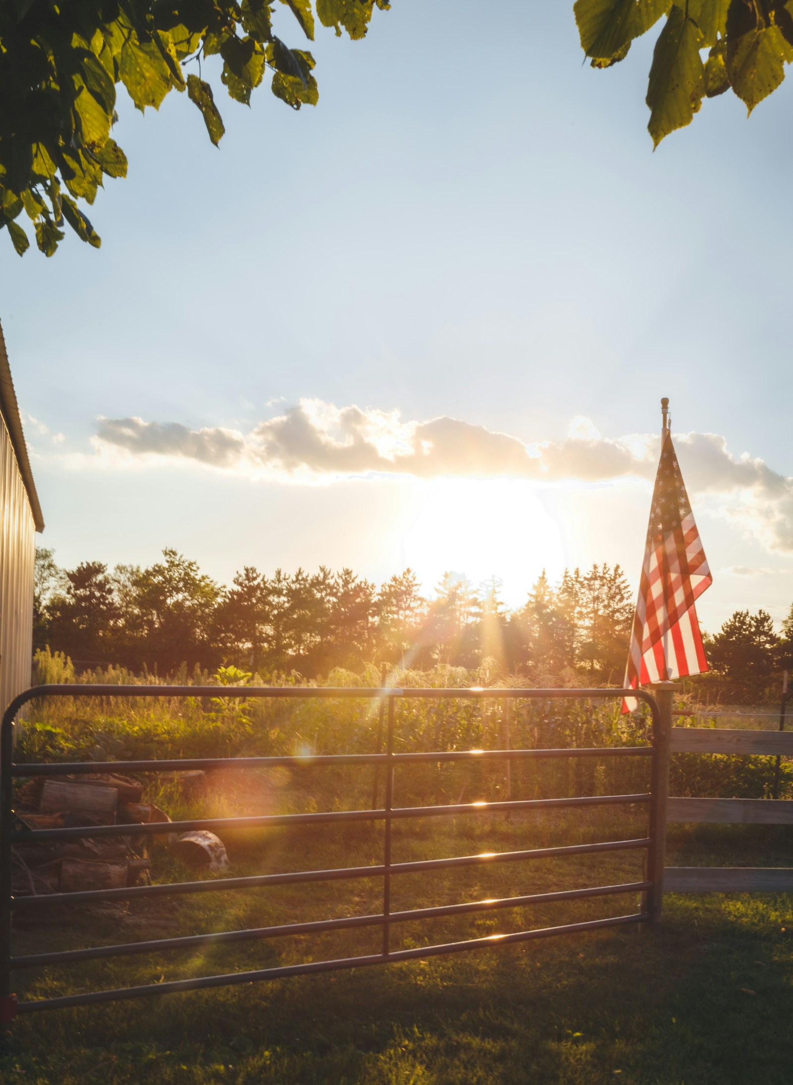 An American flag on a fence at sunset