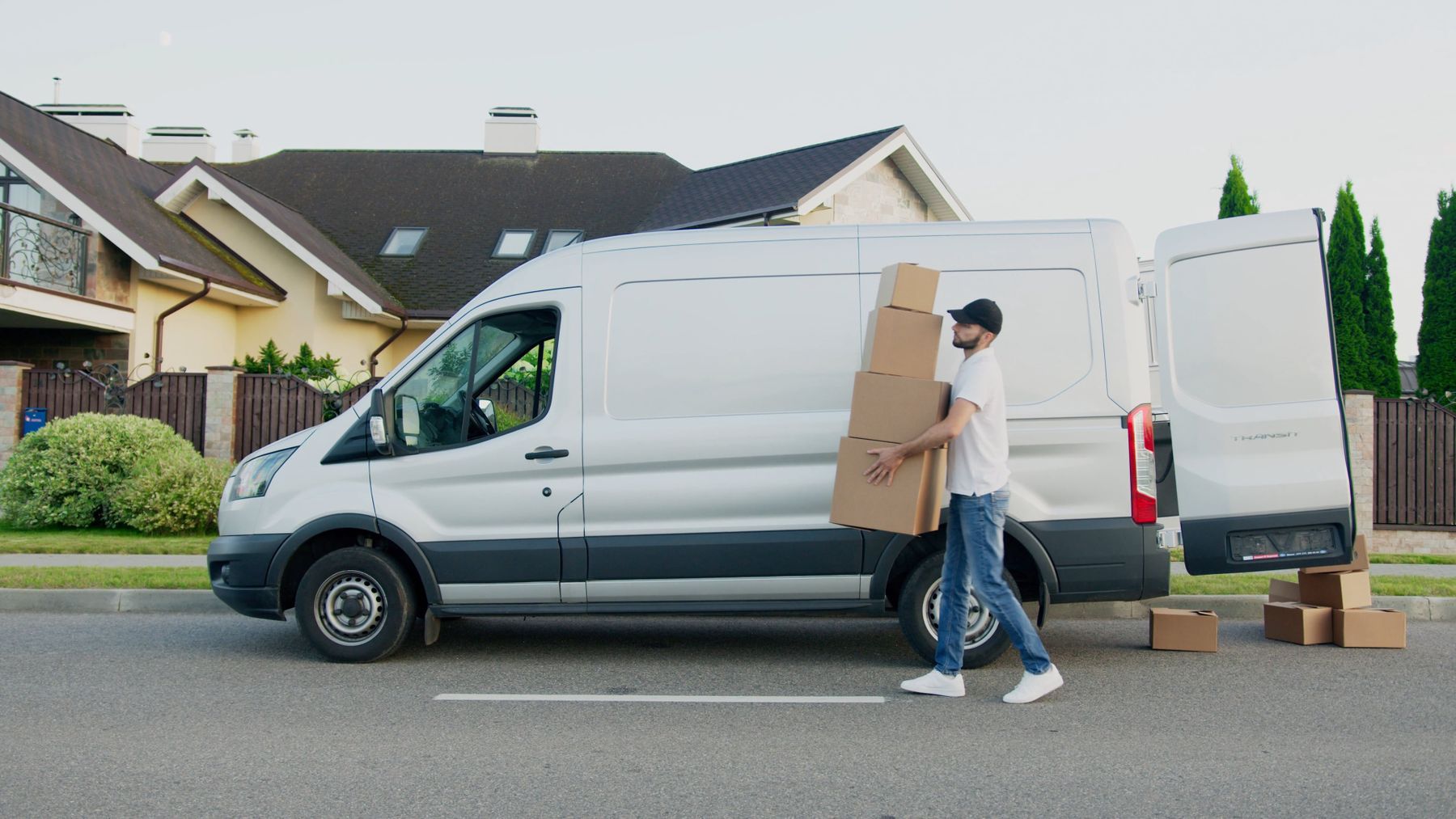 A crew member unloading rental equipment from a white delivery van